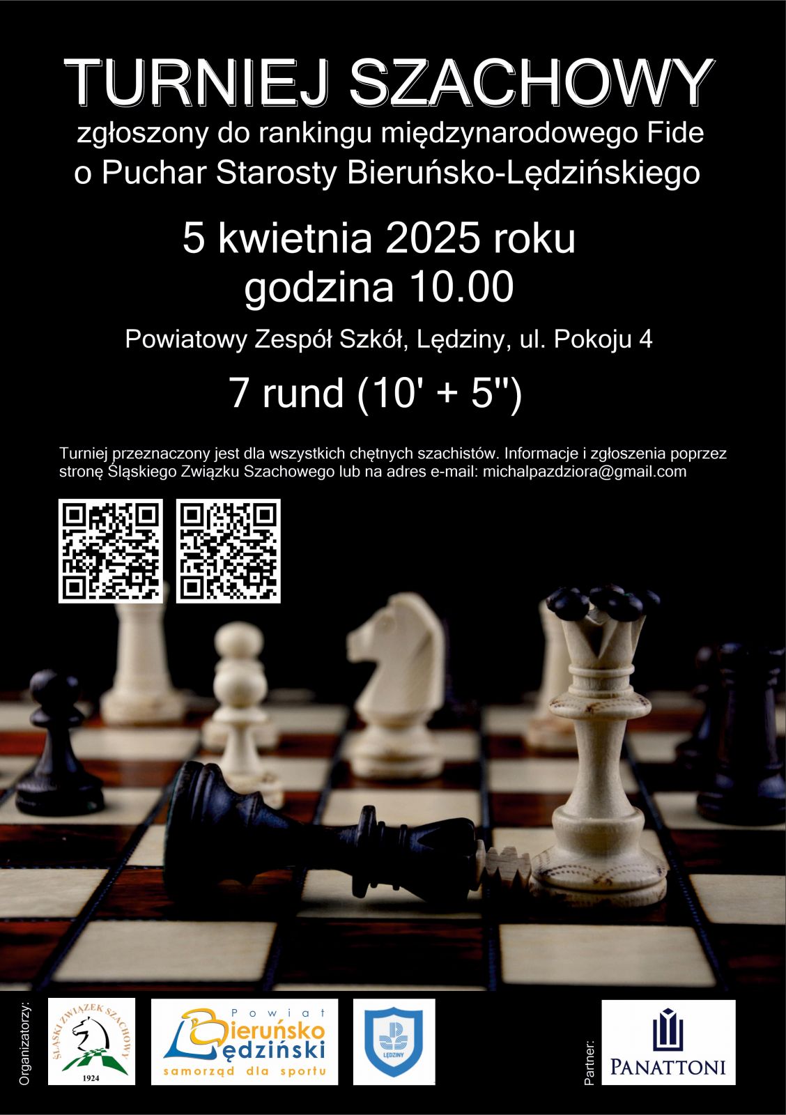 Crny plakat, na górze biały napis turniej szachowy zgłoszony do rankingu międzynarodowego Fide o Puchar Starosty  Bieruńsko-Lędzińskiego. W środkowej części z lewej strony na białym tle umieszczone są dwa kody QR. Na dole zdjęcie szachownicy z pionkami. Jeden czarny pionek leży na szachownicy. Na samym dole loga organizatorów oraz partnera wydarzenia.