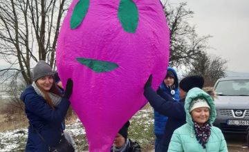 Napełnaianie fioletowego balonu w kształcie buzi ogrzanym powietrzem