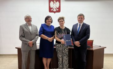 Nauczycielka z dyplomem oraz kwiatami wraz z Zarządem Powiatu