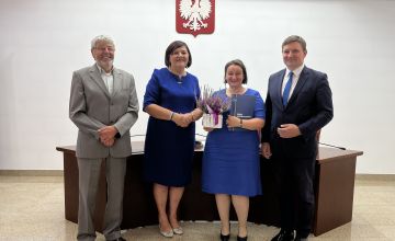 Nauczycielka z dyplomem oraz kwiatami wraz z Zarządem Powiatu