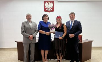 Nauczycielka z dyplomem oraz kwiatami wraz z Zarządem Powiatu