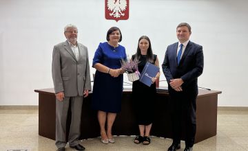 Nauczycielka z dyplomem oraz kwiatami wraz z Zarządem Powiatu