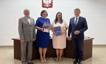 Nauczycielka z dyplomem oraz kwiatami wraz z Zarządem Powiatu
