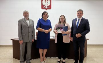 Nauczycielka z dyplomem oraz kwiatami wraz z Zarządem Powiatu